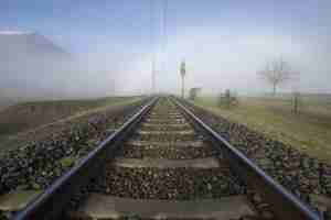 Foto gratuita bello scatto di una ferrovia con una nebbia bianca