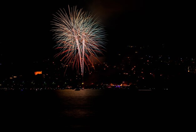 夜のスイスの湖の上の赤い花火の美しいショット