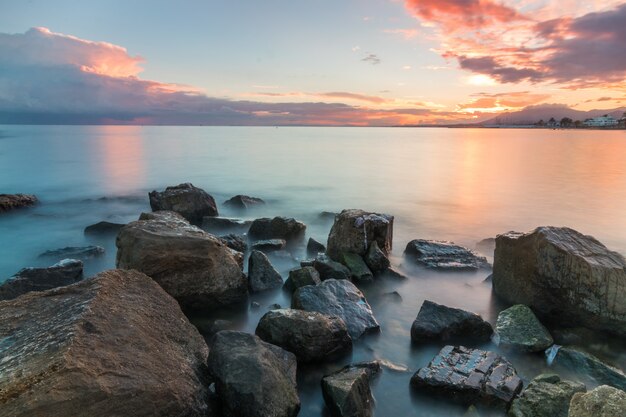 Beautiful shot of rocks on the seashore during sunset