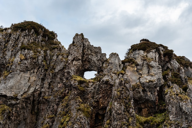 Foto gratuita bellissimo colpo di scogliere rocciose in una giornata piovosa vicino alla spiaggia