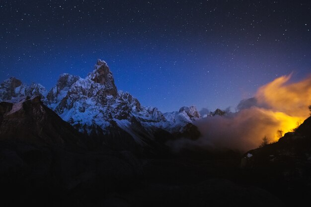 Beautiful shot of rocky mountains with a starry night sky in the background