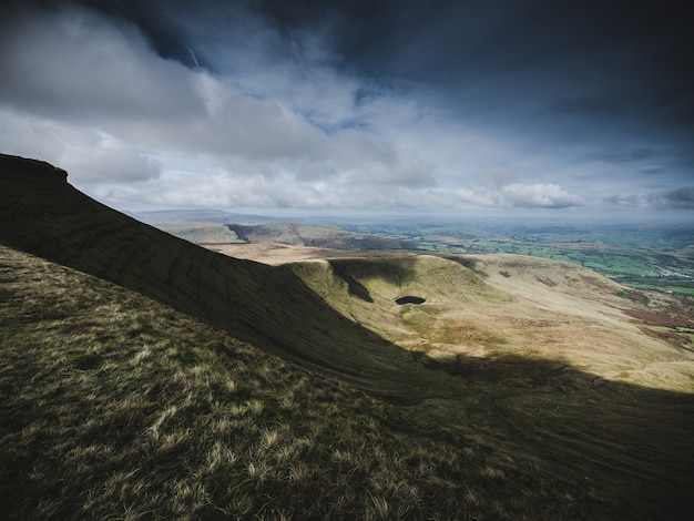 Free photo beautiful shot of rocky steep mountains and hills under a breathtaking cloudy sky