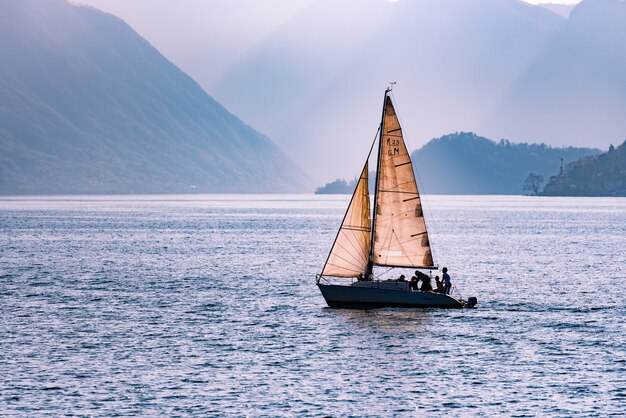 山々に囲まれた海を渡る帆船の美しいショット