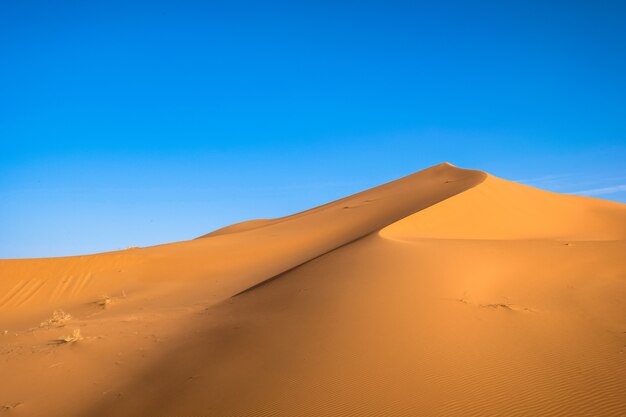 Beautiful shot of a sand dune with a clear blue sky