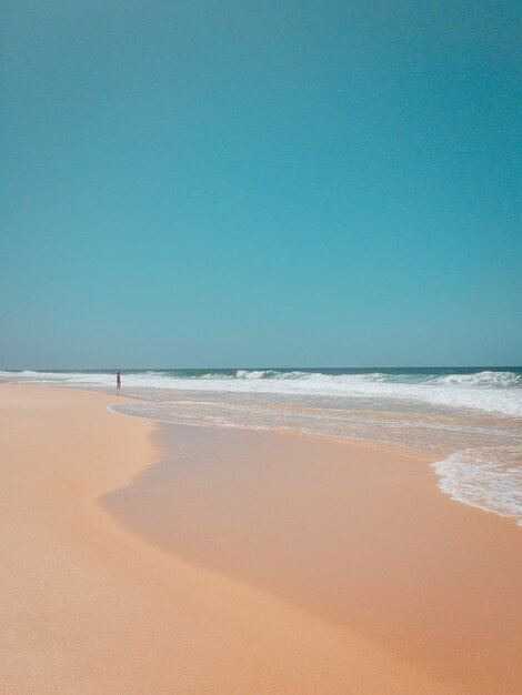 Beautiful shot of a sandy beach in rio de janeiro with strong waves of the ocean