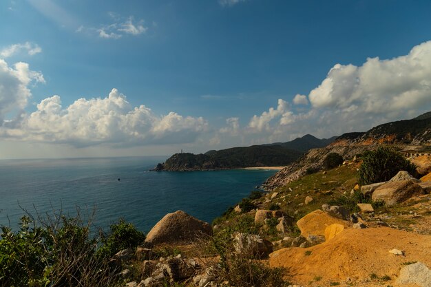 Beautiful shot of the sea near the mountains under a blue sky in Vietnam