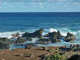 Free photo beautiful shot of sea waves splashing to the rock formations in hawaii