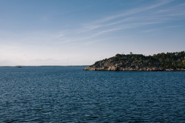 Beautiful shot of a sea with a mountain in the distance under a clear sky