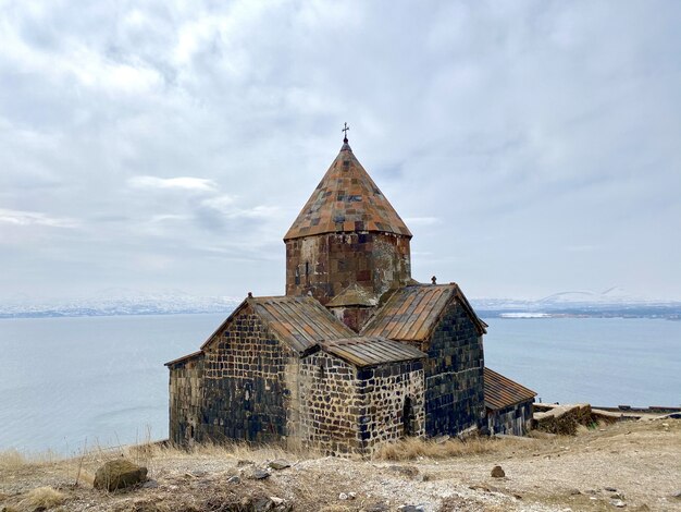 Красивый снимок монастырского комплекса Севанаванк с видом на озеро Севан в Армении