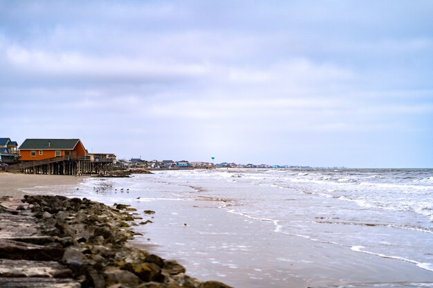 Beautiful shot of the shoreline and a wooden house in the distance