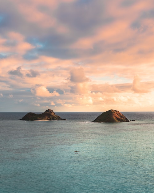 Beautiful shot of small hills in the sea under the beautiful cloudy sky