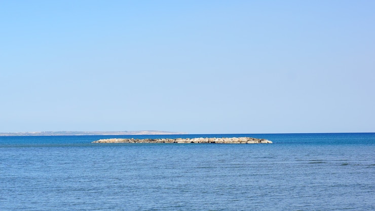 無料Photo 青空の下で海の真ん中にある小さな土地の美しいショット