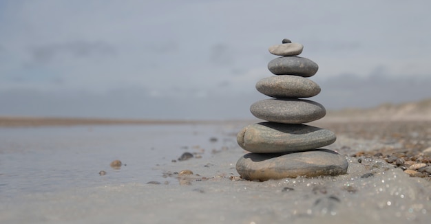 ビーチ-ビジネスの安定性の概念の岩のスタックの美しいショット