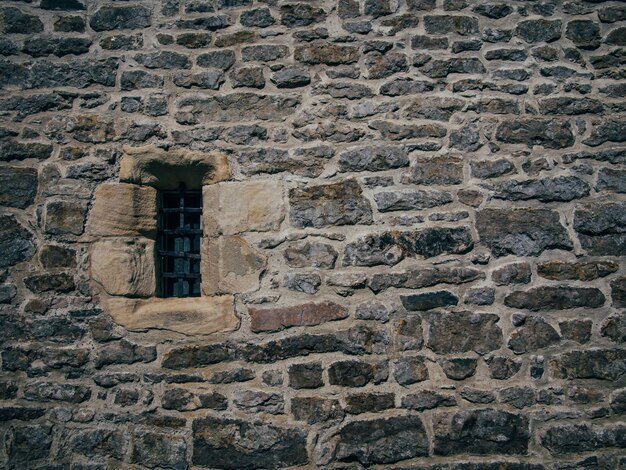 차단 된 작은 창으로 돌 벽돌 오래된 구조의 아름다운 샷