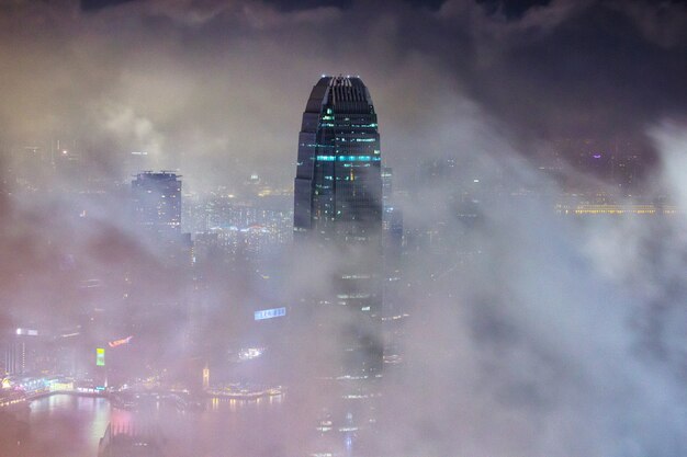 Beautiful shot of tall city buildings under a cloudy sky at night