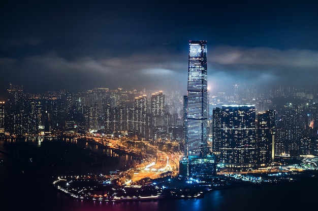 Beautiful shot of tall city buildings under a cloudy sky at night