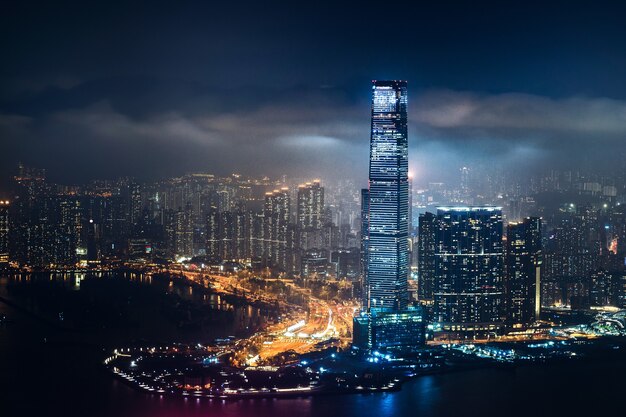 Beautiful shot of tall city buildings under a cloudy sky at night