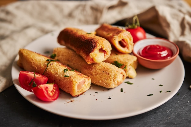 Beautiful shot of toast rolls with ham and cheese on a white plate