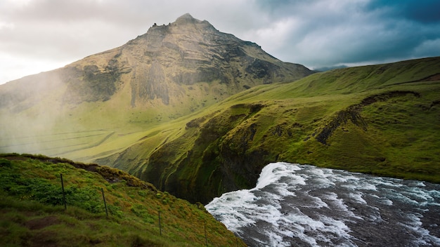 Beautiful shot of the top of a waterfall in green mountains