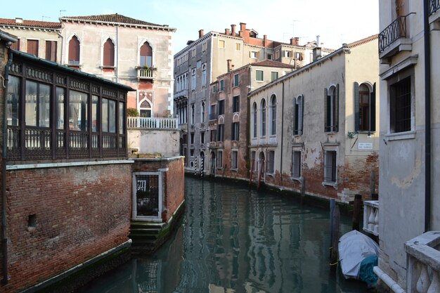 Beautiful shot of water in the middle of buildings under a blue sky