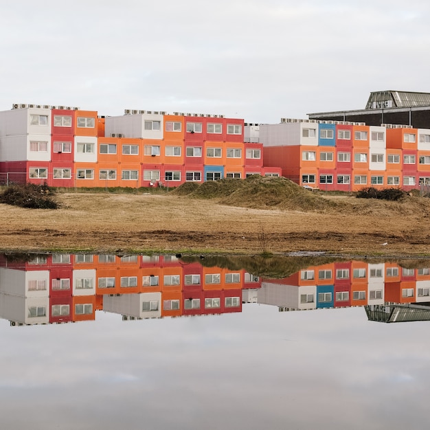 Beautiful shot of the water reflecting the buildings on the shore with a clear sky