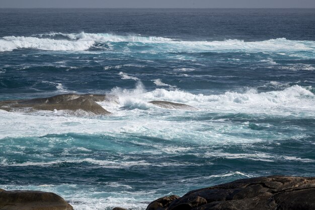 Красивый снимок волнистого океана с камнями в воде