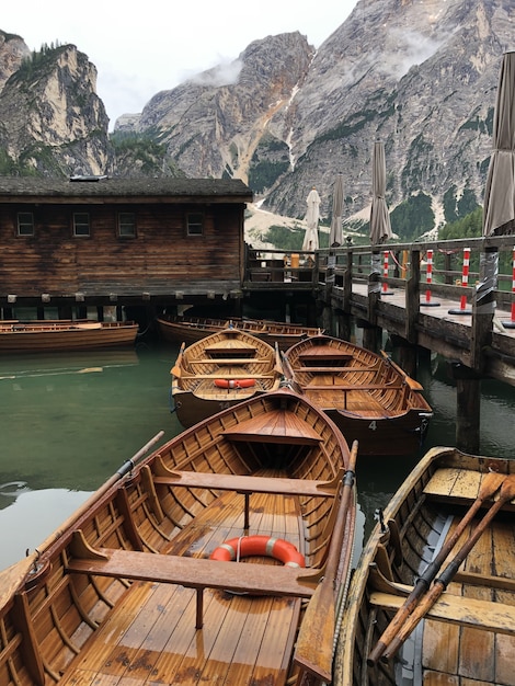 Foto gratuita bellissimo scatto di barche in legno sul lago di braies, sulla superficie delle dolomiti, trentino-alto adige, pa