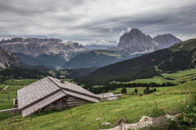 Beautiful shot of a wooden house in the green valley Puez-Geisler Nature Park in Miscì, Italy