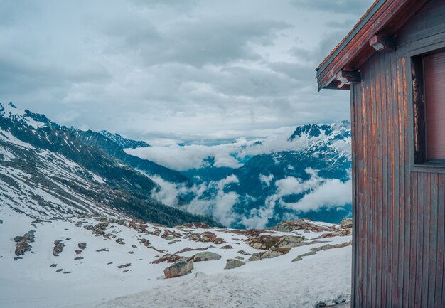 Beautiful shot of a wooden house in the mountains in winter with the grey sky in the background