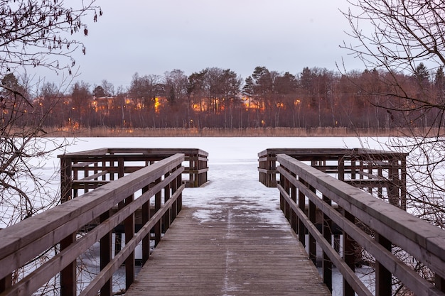 Free photo beautiful shot of wooden pathway on the riverbank and burning forest on the opposite coast