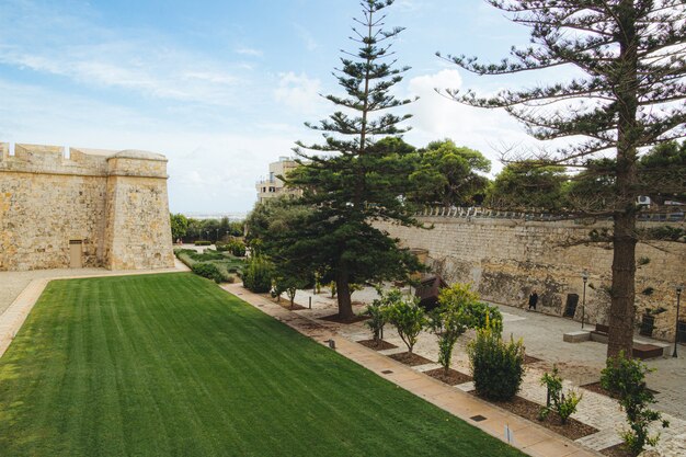 Beautiful shot of the yard in front of an old white building under the blue sky