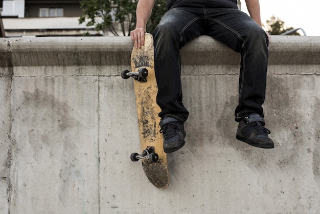 Bello scatto di un giovane maschio caucasico che fa acrobazie con lo skateboard