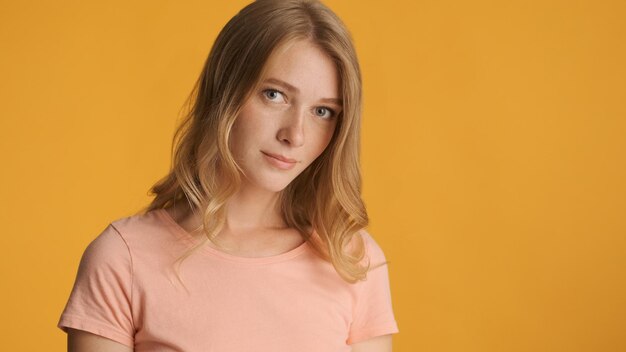 Beautiful shy blond girl posing on camera isolated on colorful background Copy space for text or advertising content