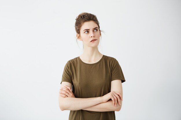 Beautiful shy young woman with hair bun thinking