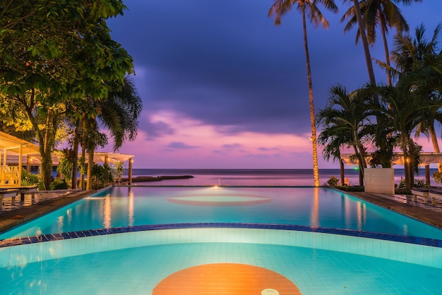 일출 실루엣 코코넛 야자수와 호텔 수영장 리조트 수영장 주변의 아름다운 실루엣 고급 우산과 의자-색상 처리를 향상