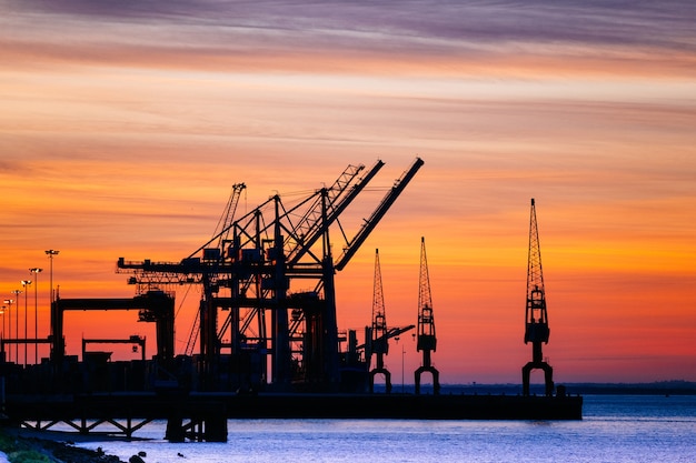 Beautiful silhouette of port machinery during sunset