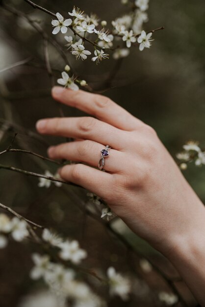 부드러운 여성의 손에 보라색 다이아몬드가있는 아름다운 실버 반지