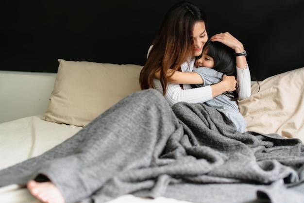 Free photo beautiful single mom and daughter girl kid hug together with love and care on bed morning happiness weeked family concept