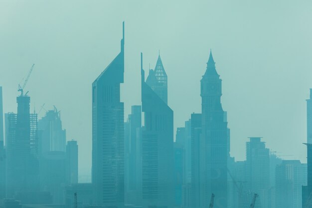 Beautiful skyline of Dubai surrounded by sand dust at day light