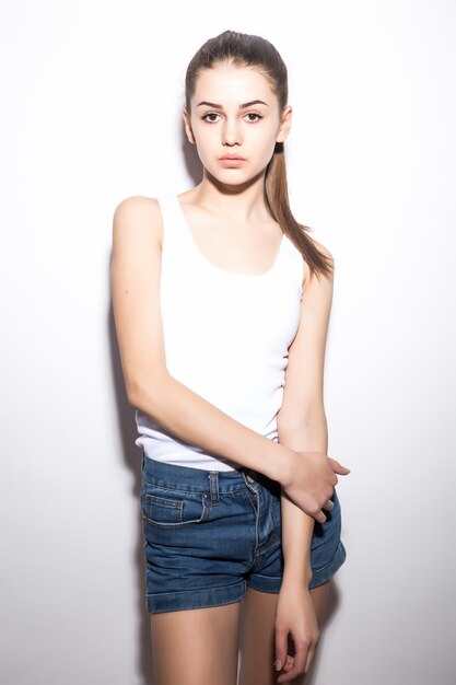 Beautiful slim woman in a t-shirt, on white