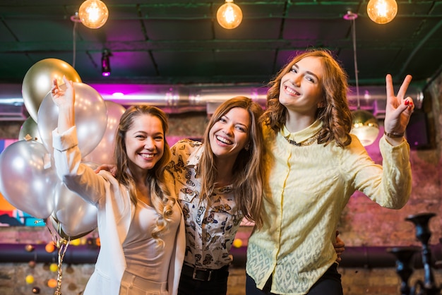 Beautiful smiling female friends enjoying party in night club