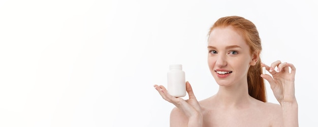 Bella ragazza sorridente che prende la bottiglia della tenuta del farmaco con la pillola femminile felice sana di cibo delle pillole