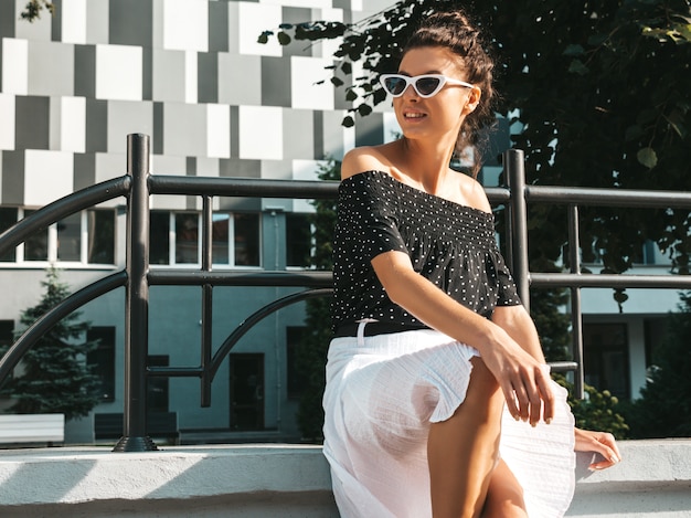 Free photo beautiful smiling model dressed in elegant summer clothes.sexy carefree girl sitting in the street.trendy modern businesswoman in sunglasses having fun