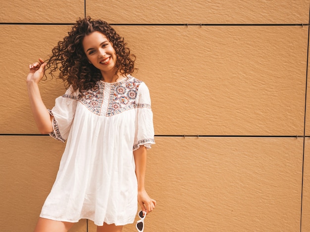 Бесплатное фото Красивая улыбающаяся модель с афро кудри прическа, одетая в летнее платье битник белое.