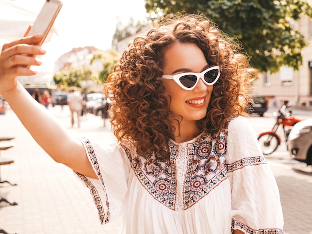 Free photo beautiful smiling model with afro curls hairstyle dressed in summer hipster white dress.