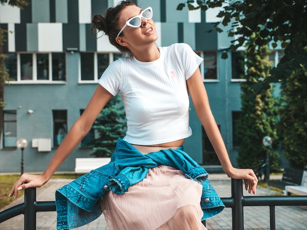 Free photo beautiful smiling model with horns hairstyle dressed in summer hipster jacket jeans clothes.sexy carefree girl posing in the street.trendy funny and positive woman having fun in sunglasses