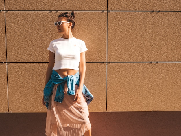 Free photo beautiful smiling model with horns hairstyle dressed in summer hipster white t-shirt clothes.sexy carefree girl posing in the street near wall.trendy funny and positive woman having fun in sunglasses