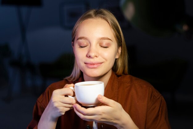 Красивая улыбающаяся женщина пьет кофе