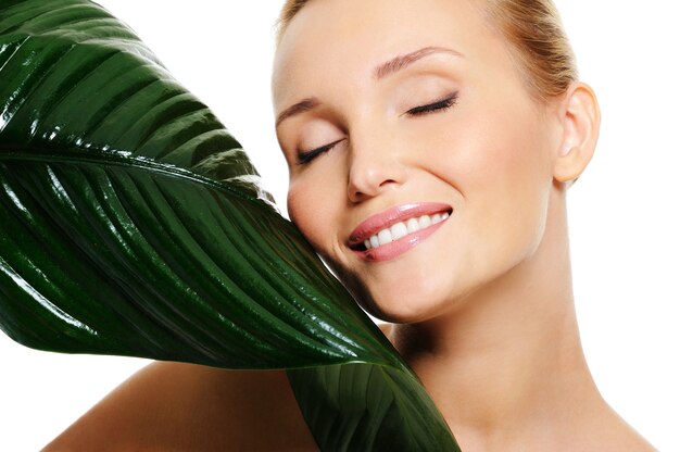 Beautiful smiling woman and fresh green leaf