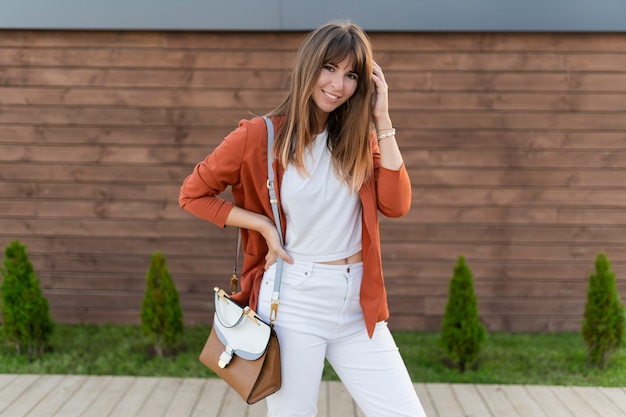 Beautiful smiling  woman in jacket posing  in the city.